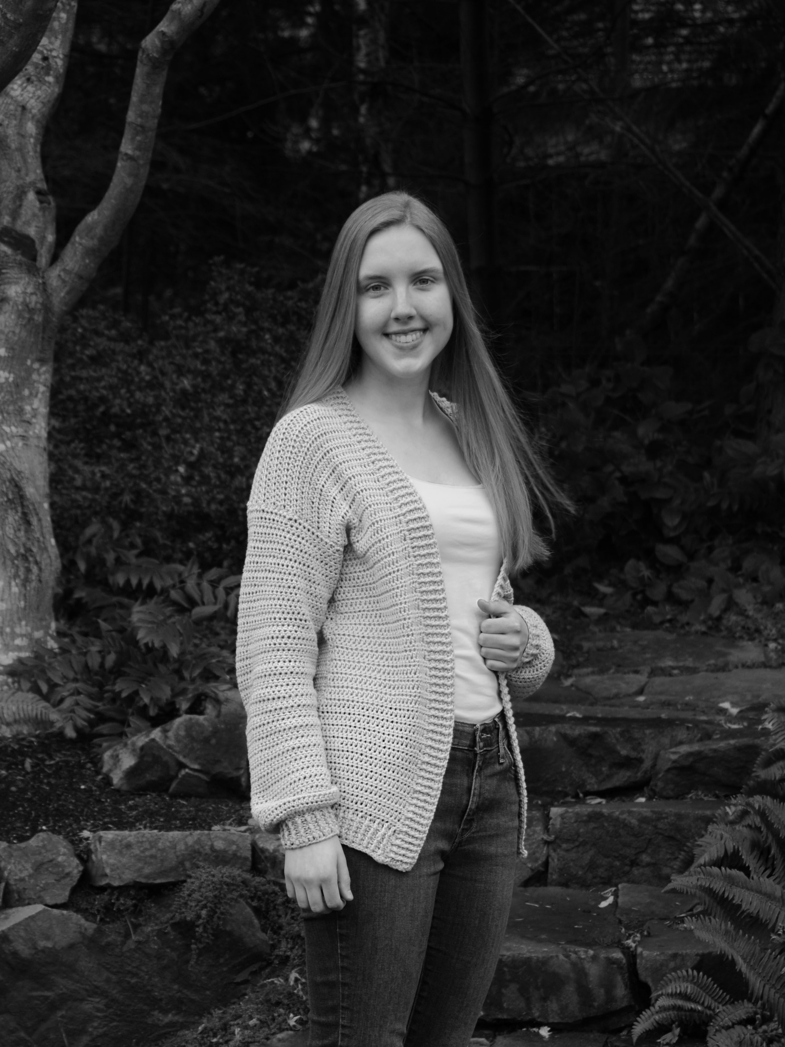 black and white headshot of Emily who has long hair and is smiling at the camera
